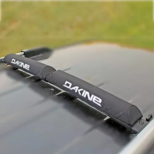 Cojines para barras Aero Rack Pad de DAKINE en color negro, diseñados para proteger y asegurar las cargas en racks de bicicleta.